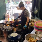Jay Fai, the cook, cooking at a small gas stove in her Bangkok restaurant.