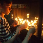 Nepal with Kids tourist children lighting candles at a temple in nepal