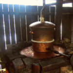 Lunch in the Tuica Shed. Making Tuica in Maramures tuica romania - the copper still for distilling tuica or palinca in maramures romania